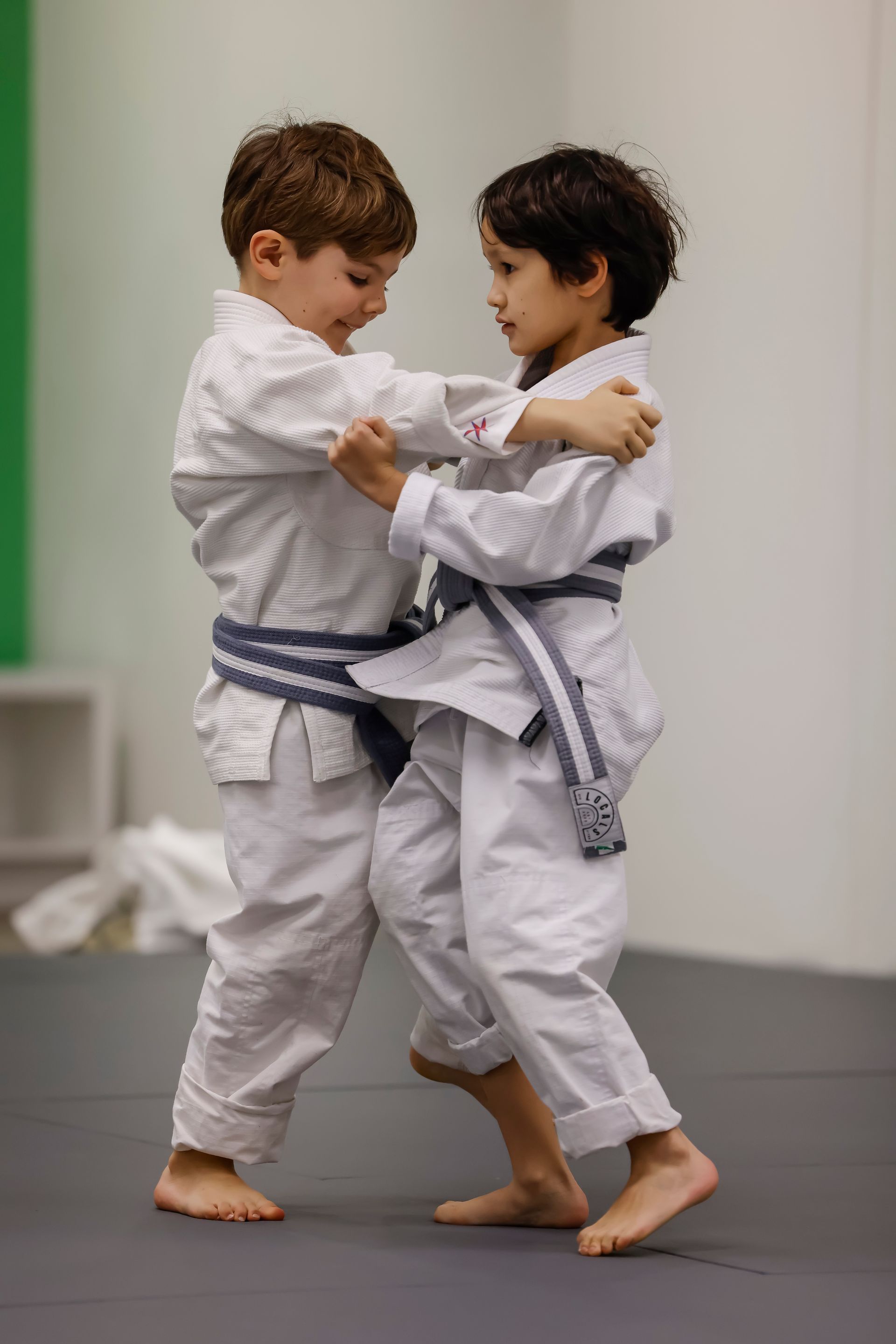 Woman intensely cycling on a stationary bike, showing effort; black and white photo.