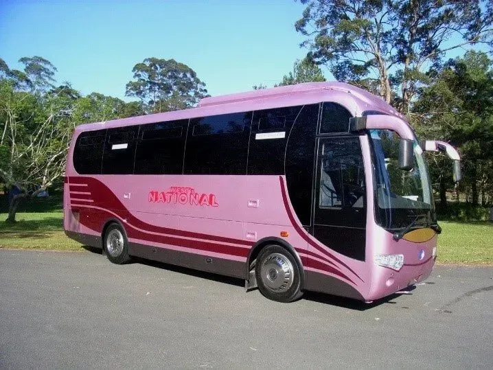A Large Pink Bus is Parked in a Parking Lot — Wests National Coaches In Chevallum, QLD
