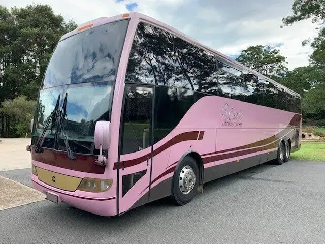 A Pink and Brown Bus is Parked on the Side of the Road — Wests National Coaches In Chevallum, QLD