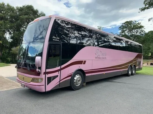 A Pink and Brown Bus is Parked in a Parking Lot — Wests National Coaches In Chevallum, QLD