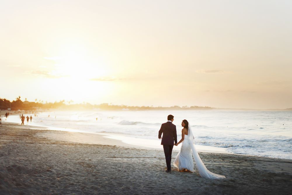 Bride and groom walking along the beach