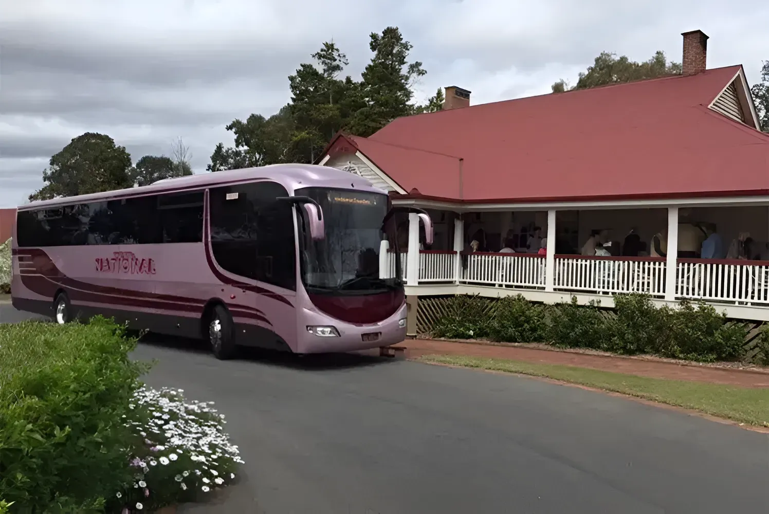A Bus is Parked in Front of a House With a Red Roof — Wests National Coaches In Chevallum, QLD