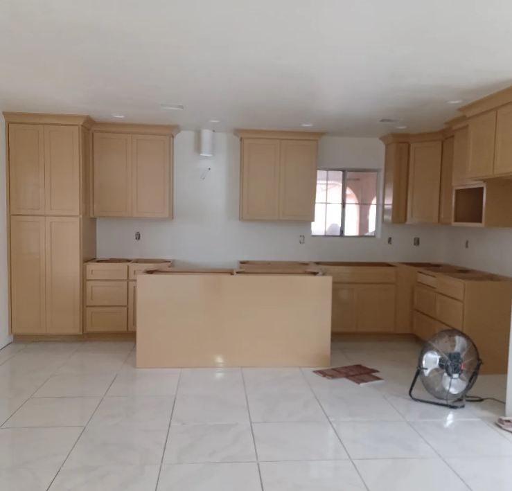 A kitchen with blue cabinets and gold handles.
