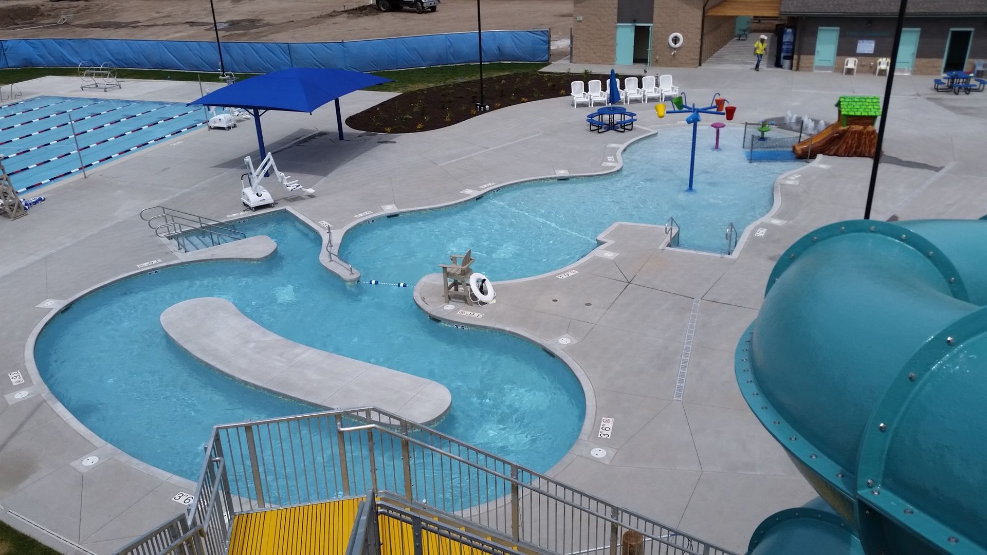 Overhead view of a public pool with a lazy river, water slides, and a lap pool.