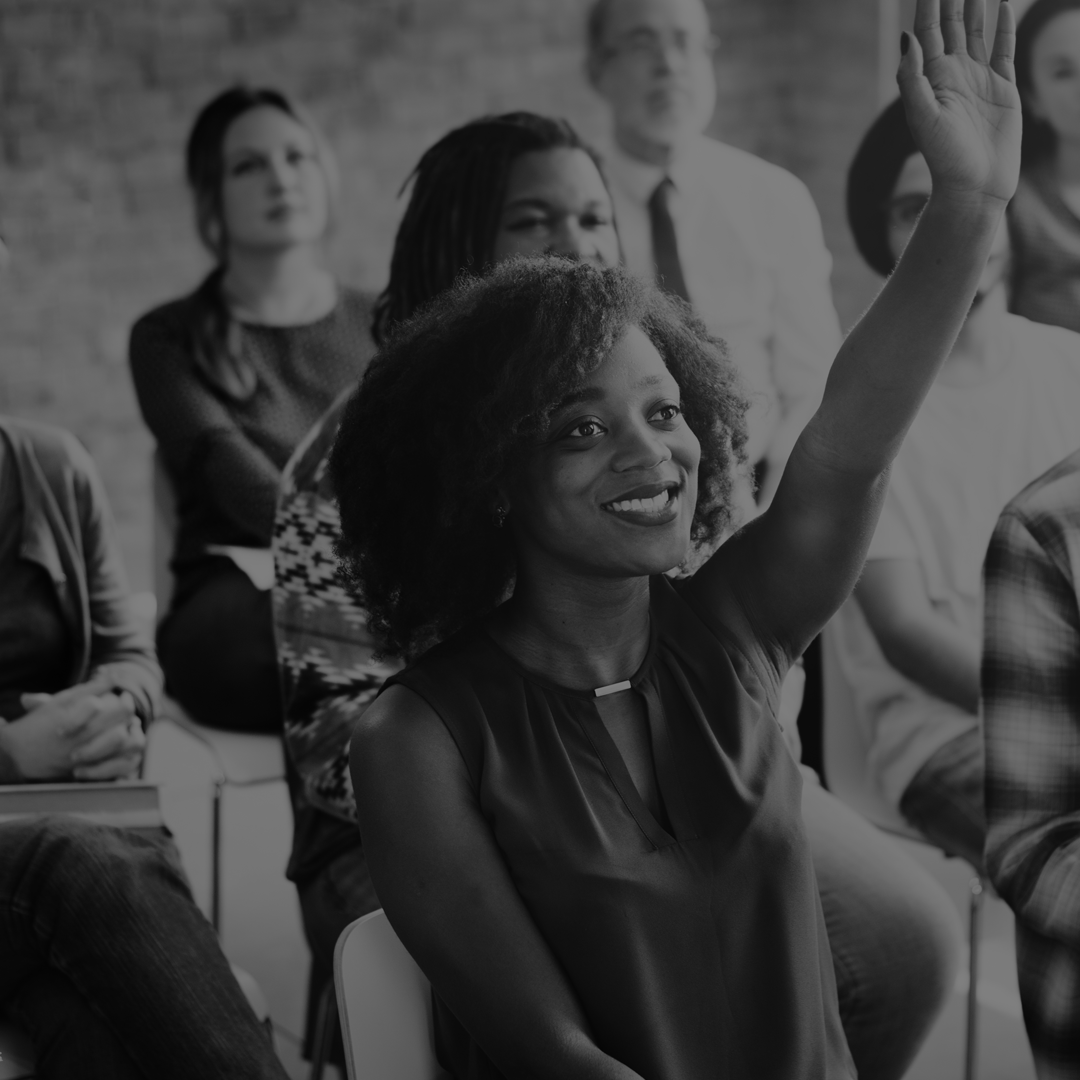 A woman is raising her hand in a black and white photo.