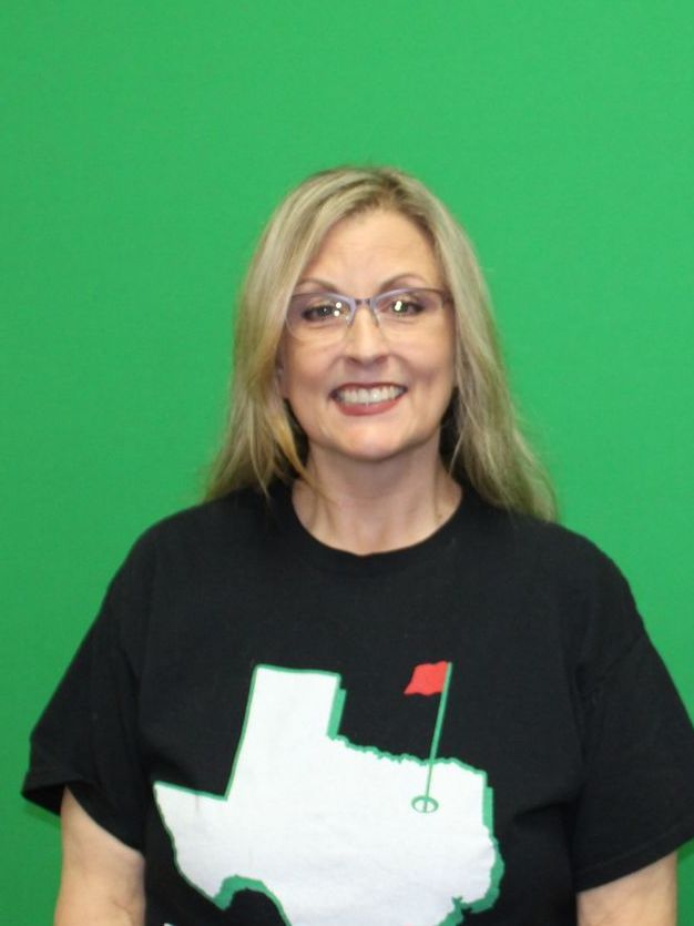A woman is sitting in a wheelchair and smiling for the camera.