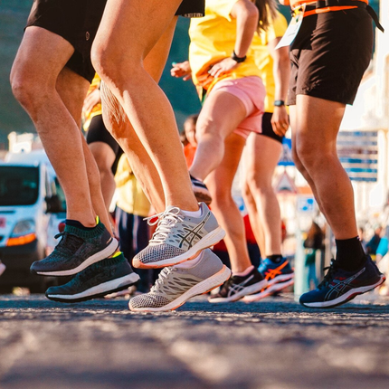 A group of people are running down a street.