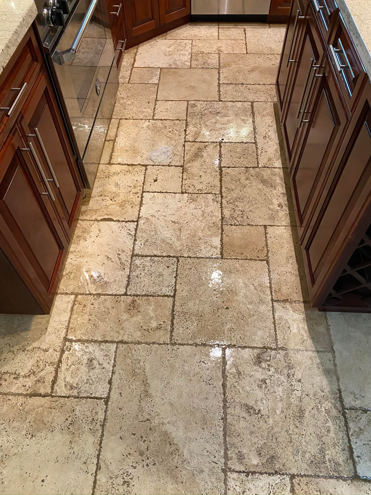 A kitchen with a tile floor and wooden cabinets.