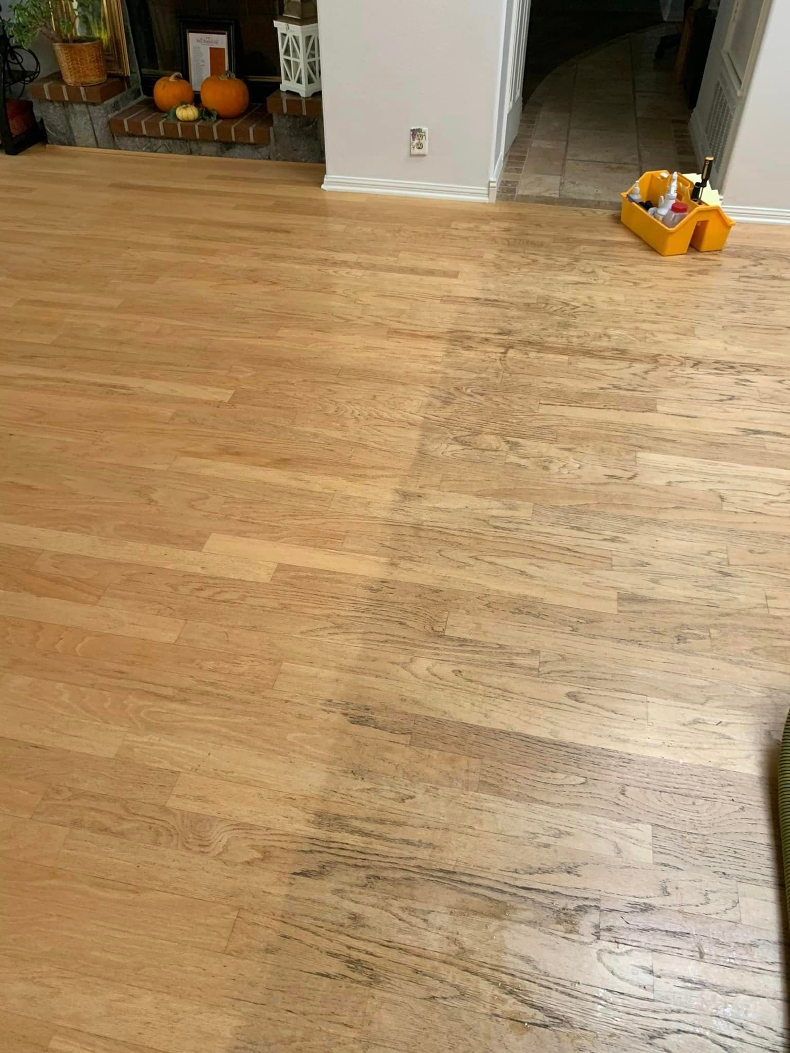 A living room with a wooden floor and a fireplace.