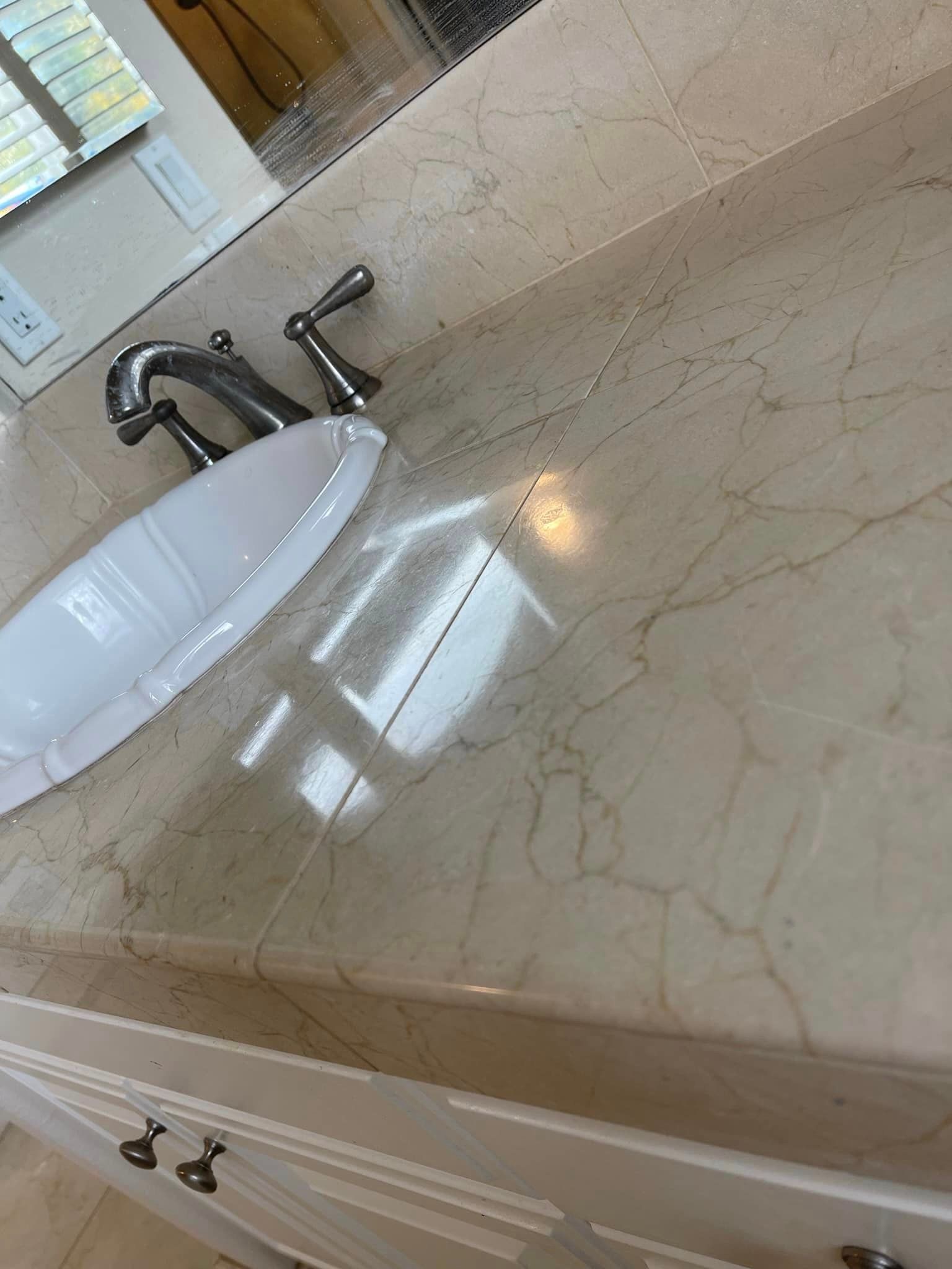 A bathroom sink with a marble counter top and a mirror.