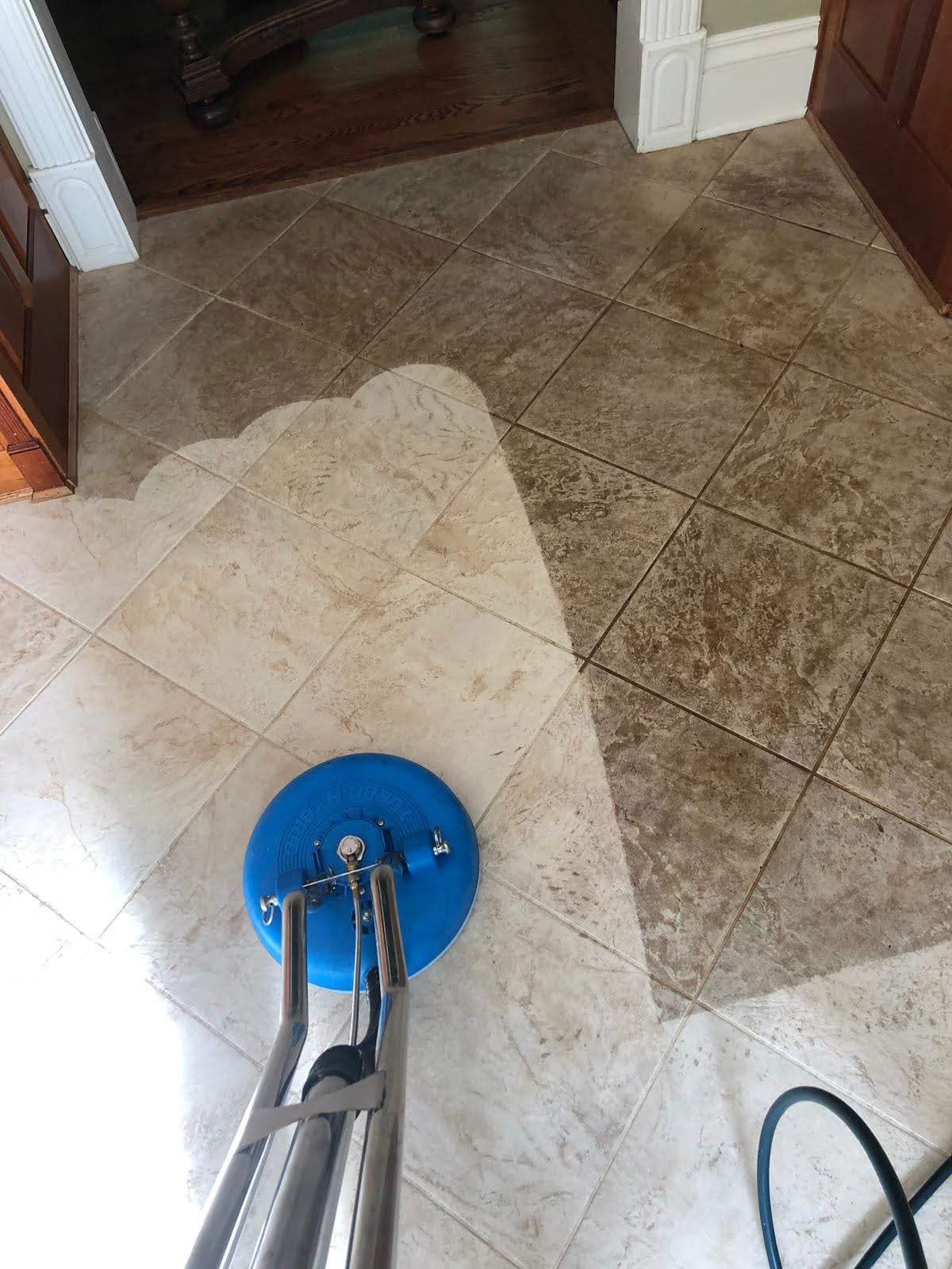 A vacuum cleaner is cleaning a tile floor in a room.