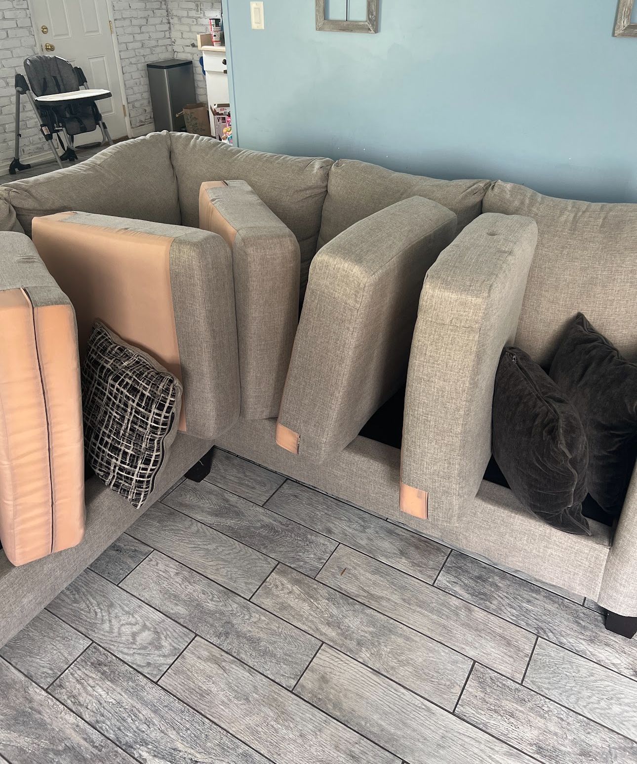A white couch is sitting in a living room next to a window.