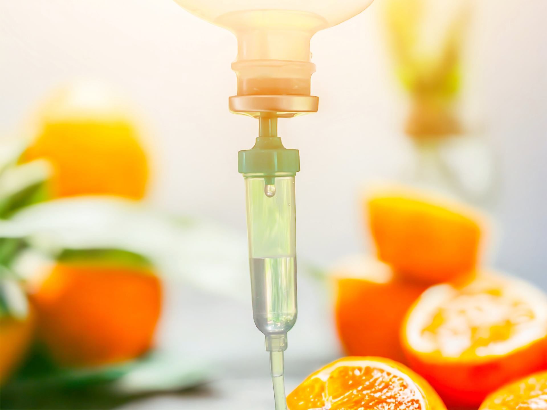 IV drip with liquid suspended over oranges.