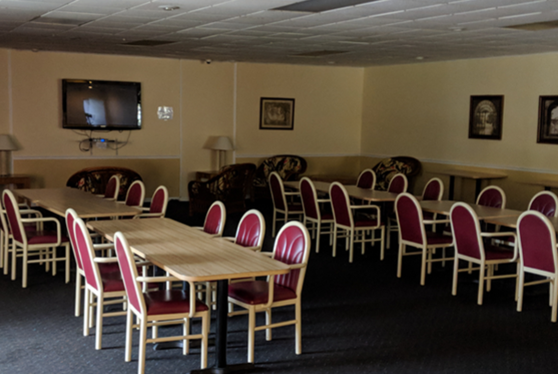 a dining room with tables and chairs and a flat screen tv
