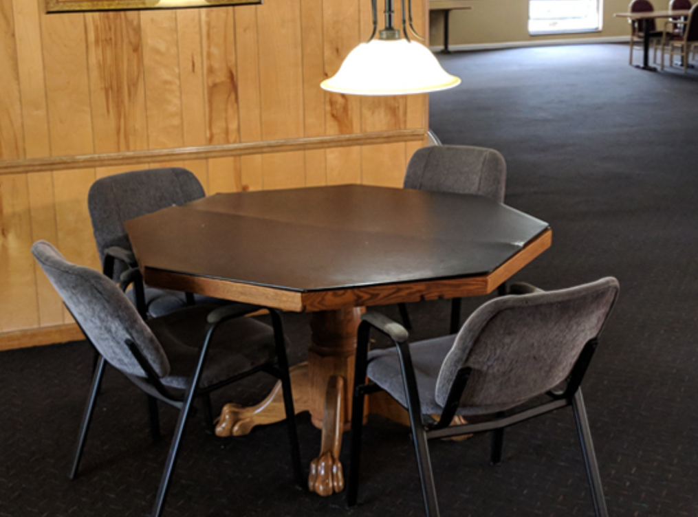 a table and chairs in a room with wood paneling