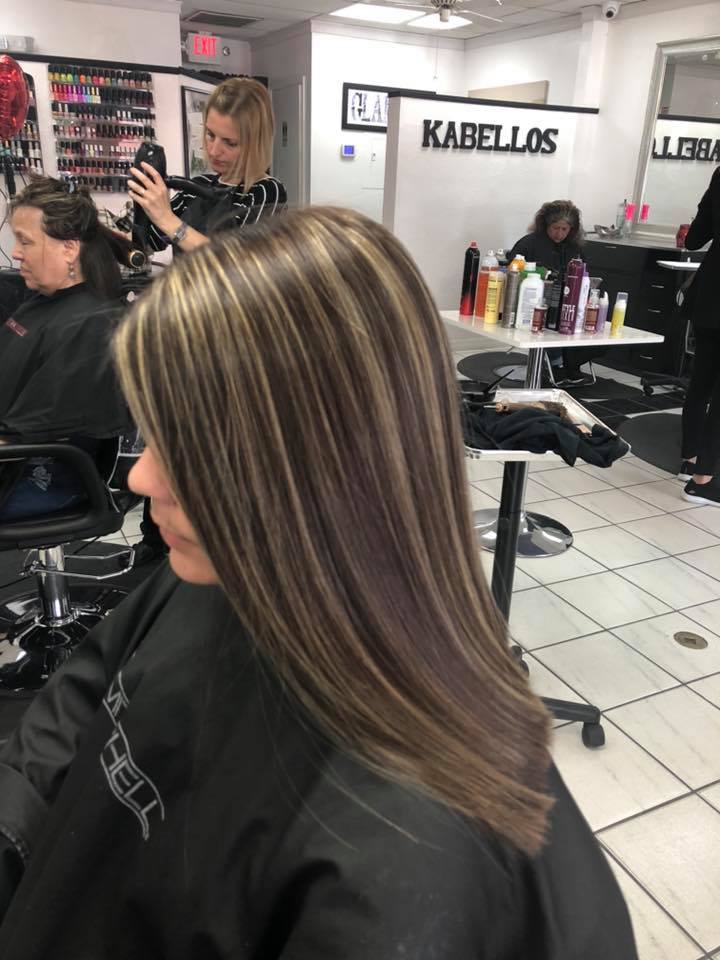 A woman is getting her hair cut in a salon.
