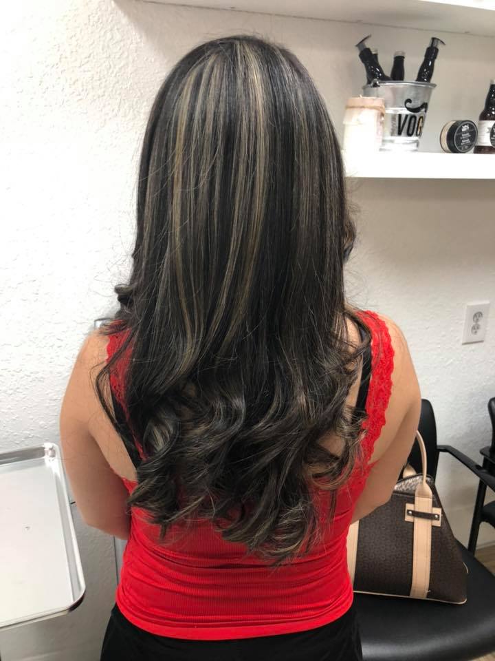 The woman is wearing a red tank top and has long hair.