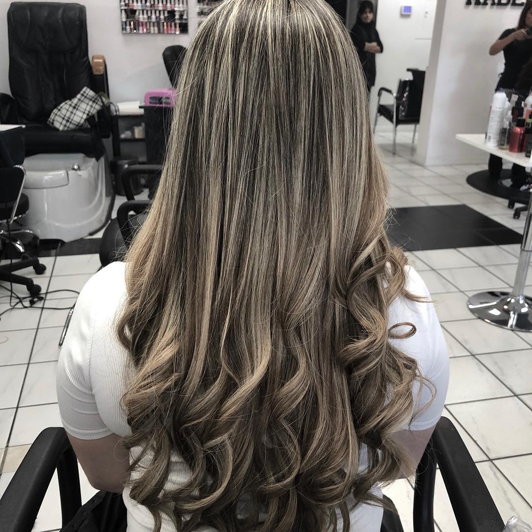 A woman with long hair is sitting in a chair in a salon