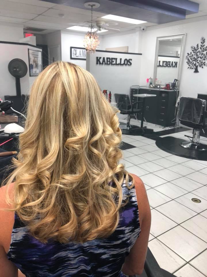 A woman with blonde hair is sitting in a hair salon.