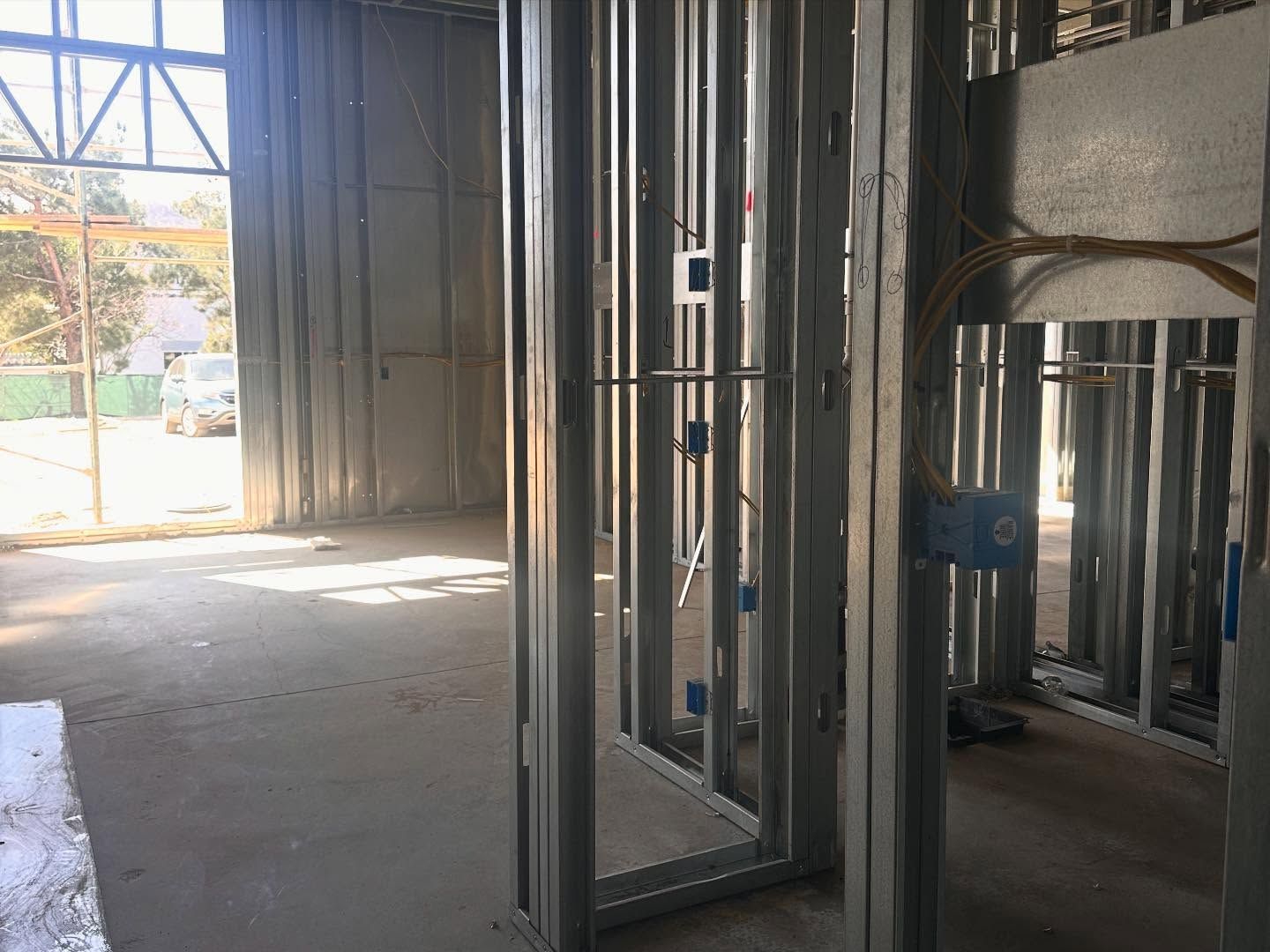 Interior construction: Metal framing with electrical boxes. Daylight through large window.