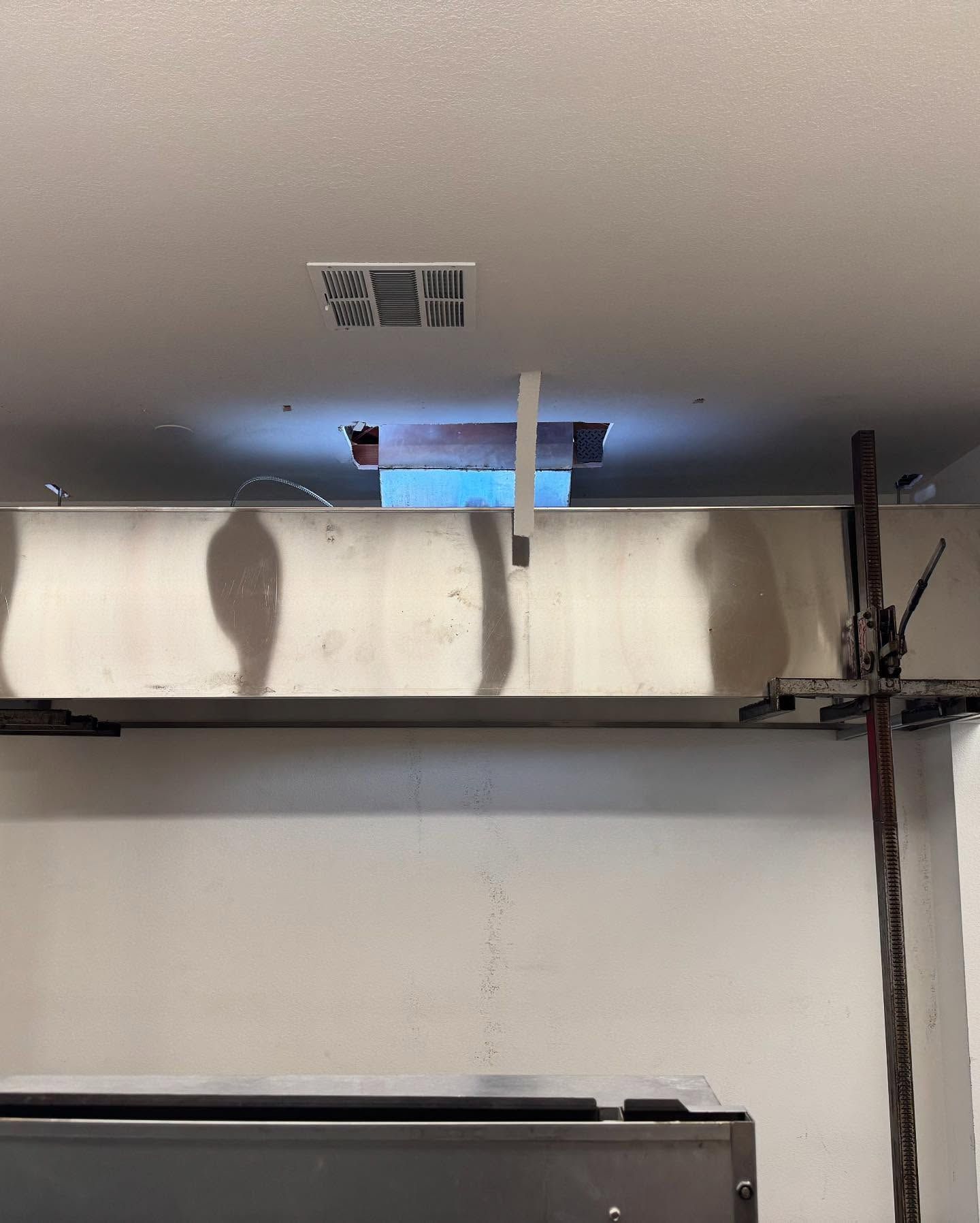 Ceiling with a square hole, metal beam, and support prop.