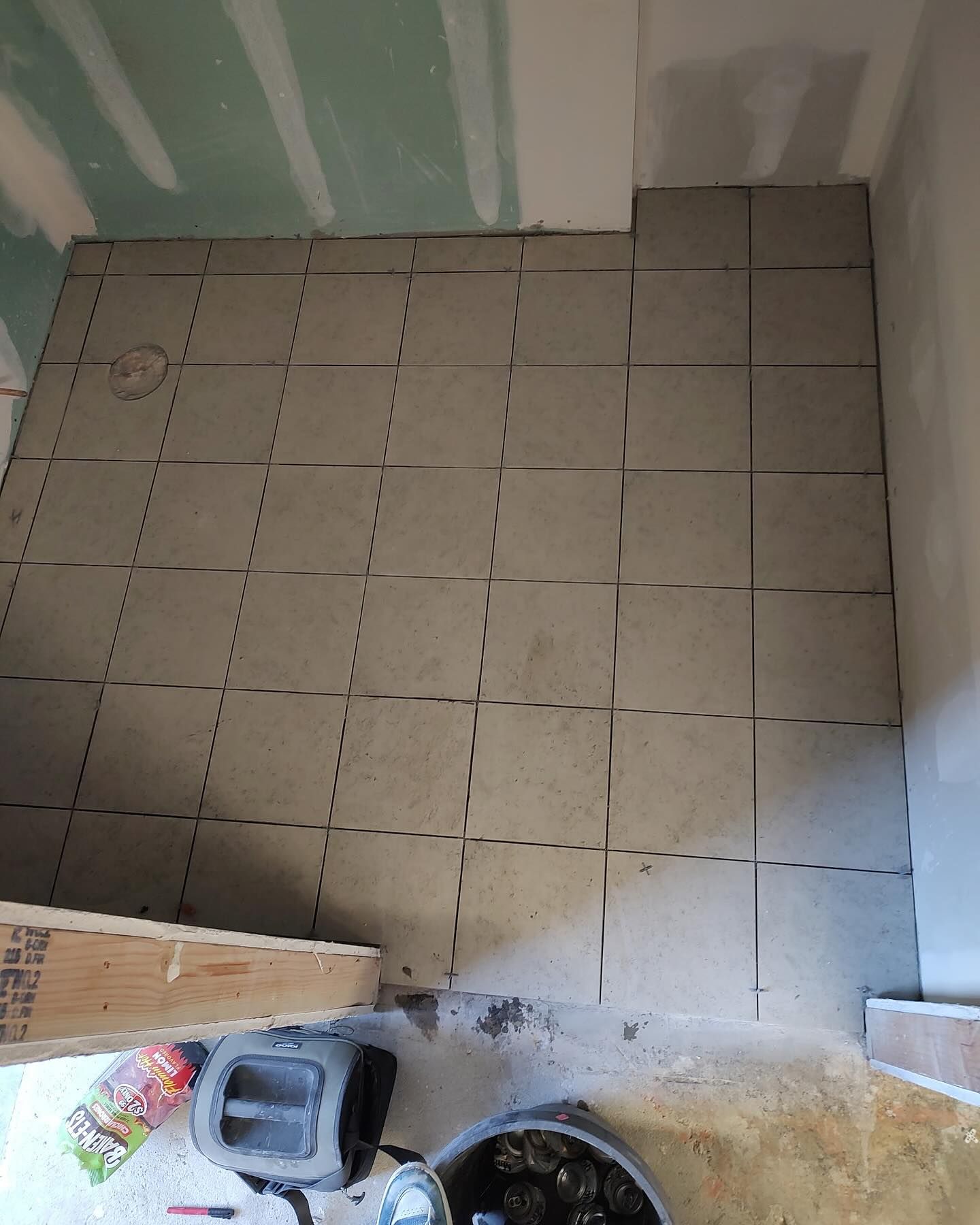 Gray tiles being laid on a floor; a renovation project in progress.