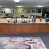 Lobby reception desk with glass display cases and a patterned rug in front