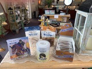 Tabletop display of assorted packaged snacks and candles in a cozy shop or café interior