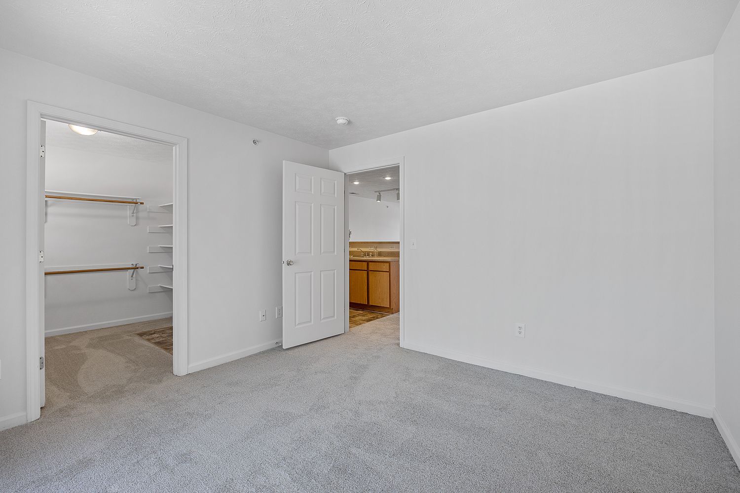 The Elm floor plan bedroom with carpet flooring, closet space, and neutral walls.