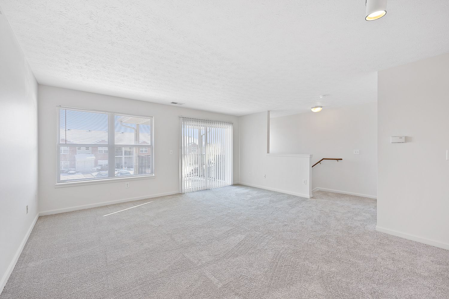 The Elm floor plan living room with large window, sliding glass doors, and bright natural light.