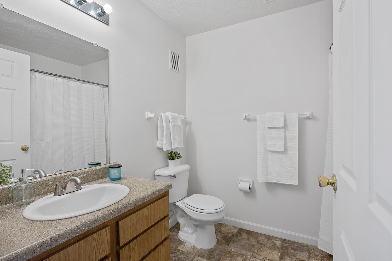 The Elm floor plan bathroom with vanity, mirror, and shower/tub combination.