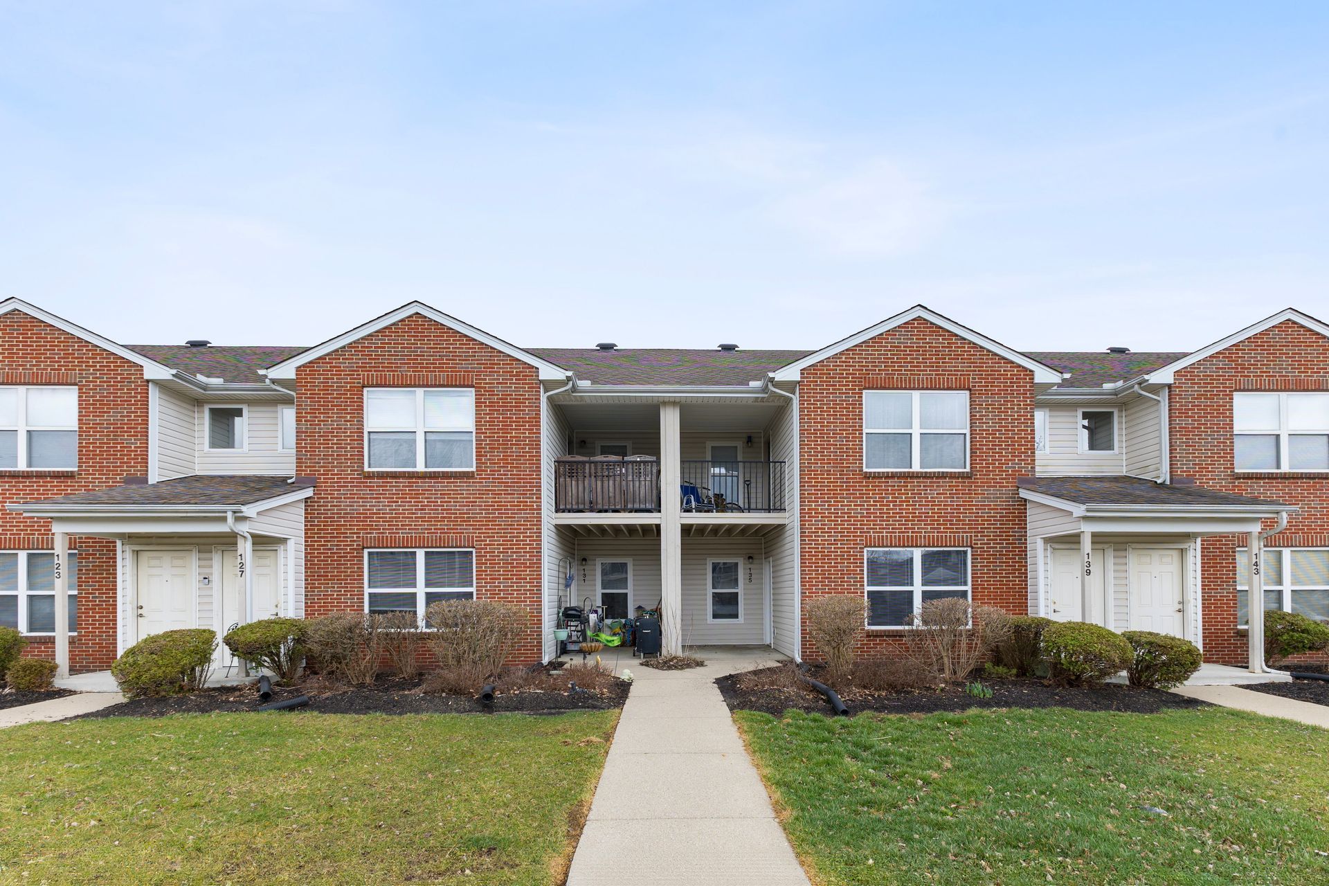 Front exterior view of Knollwood Crossing townhomes with red brick and white trim.