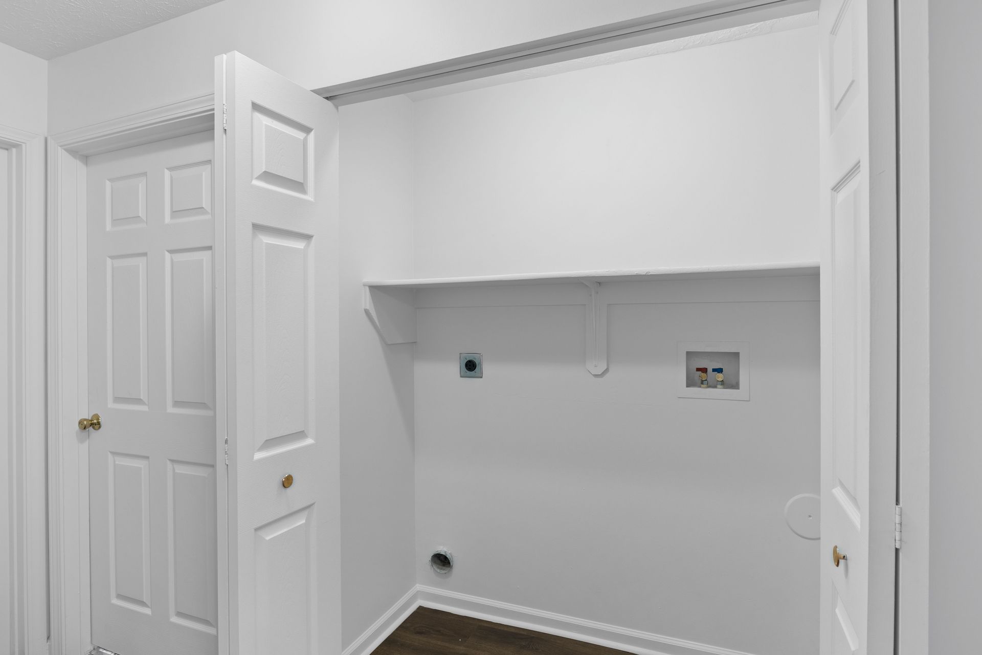 The Maple floor plan laundry area with washer and dryer connections and double doors.