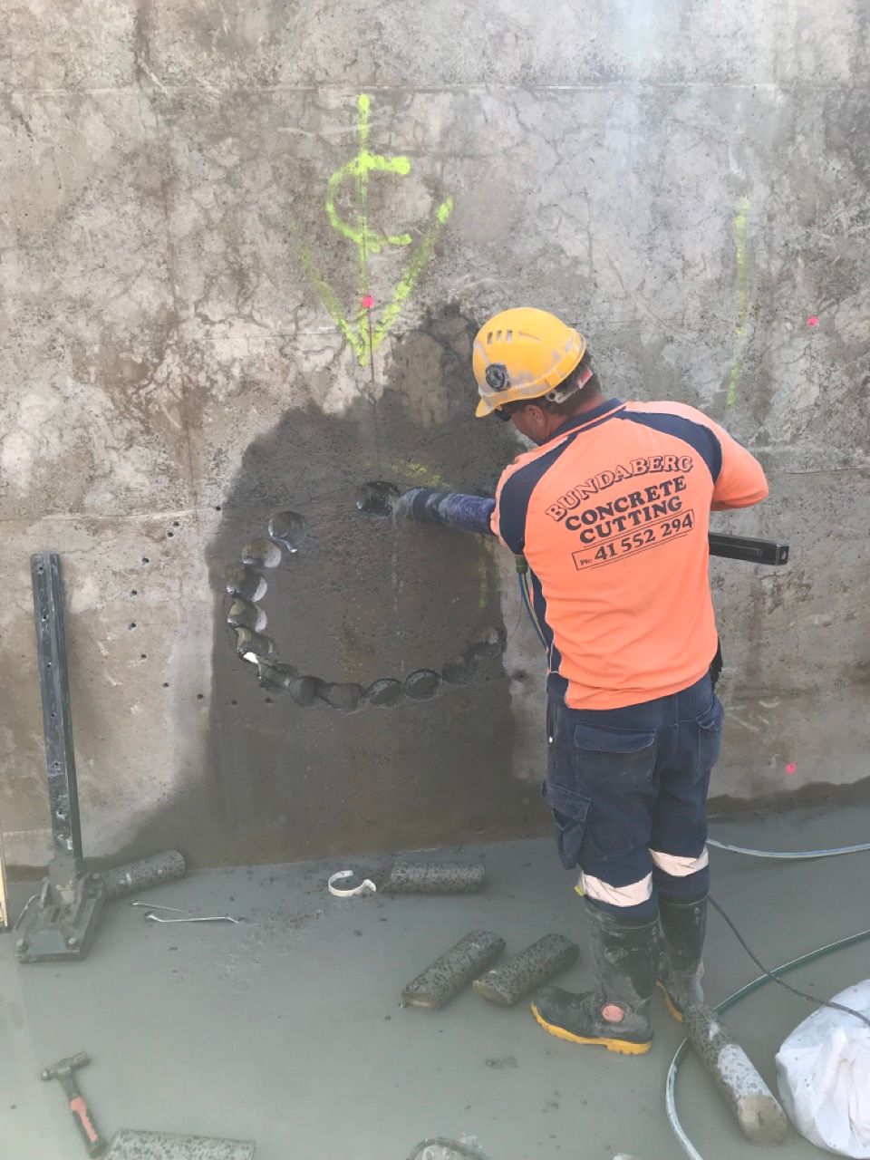 Man Core Drilling Multiple Holes— Concrete Cutting Services in Bundaberg, QLD