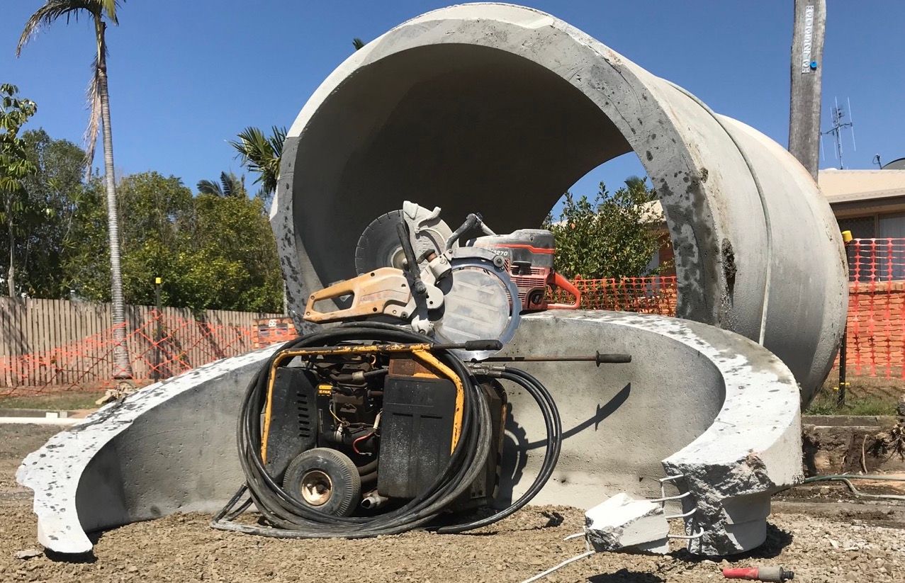 Concrete Saw Through A Pipe— Concrete Cutting Services in Bundaberg, QLD