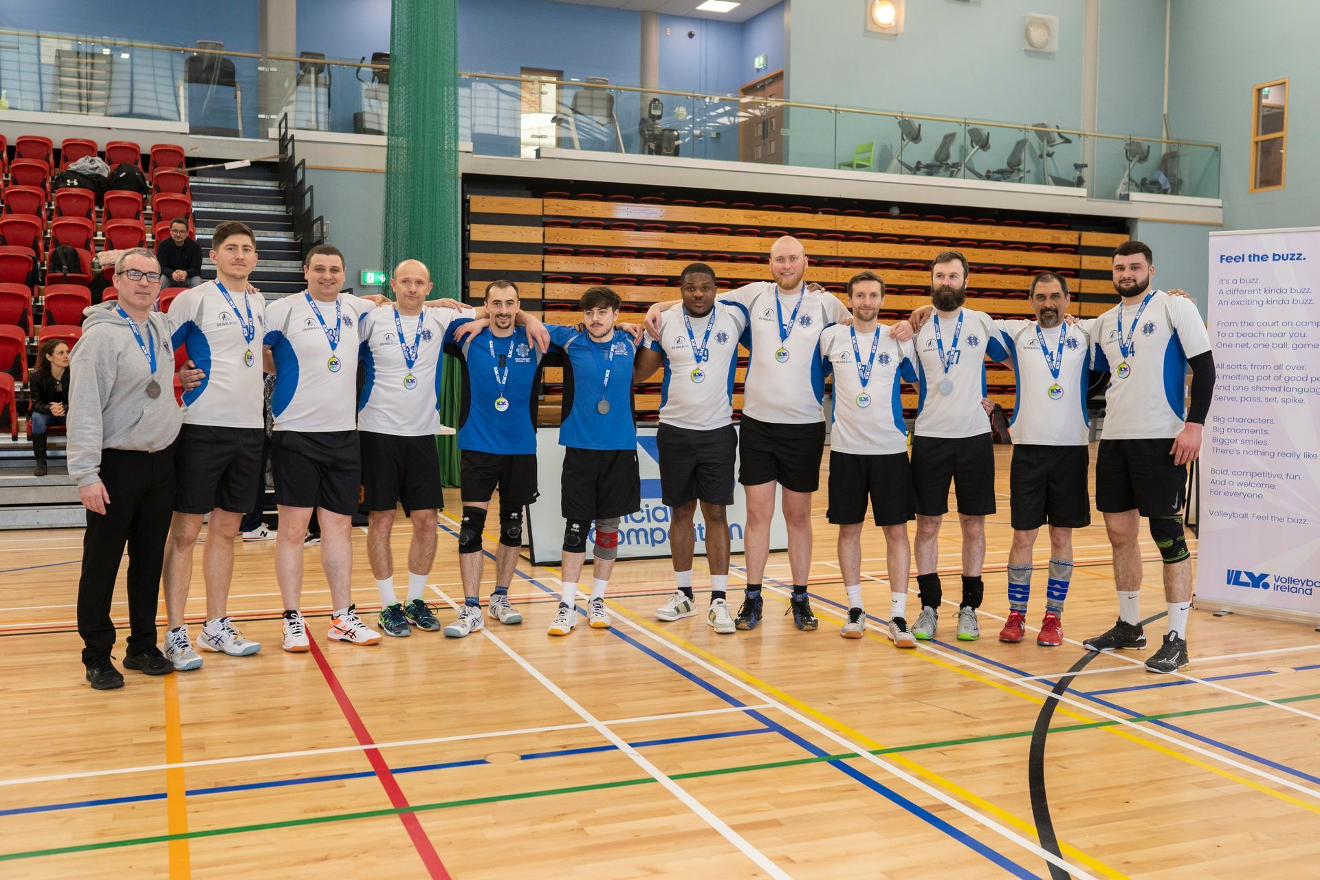 A group of men are posing for a picture on a basketball court.