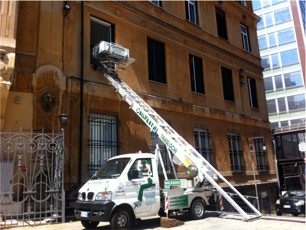 Un furgone bianco con una scala attaccata è parcheggiato davanti a un edificio