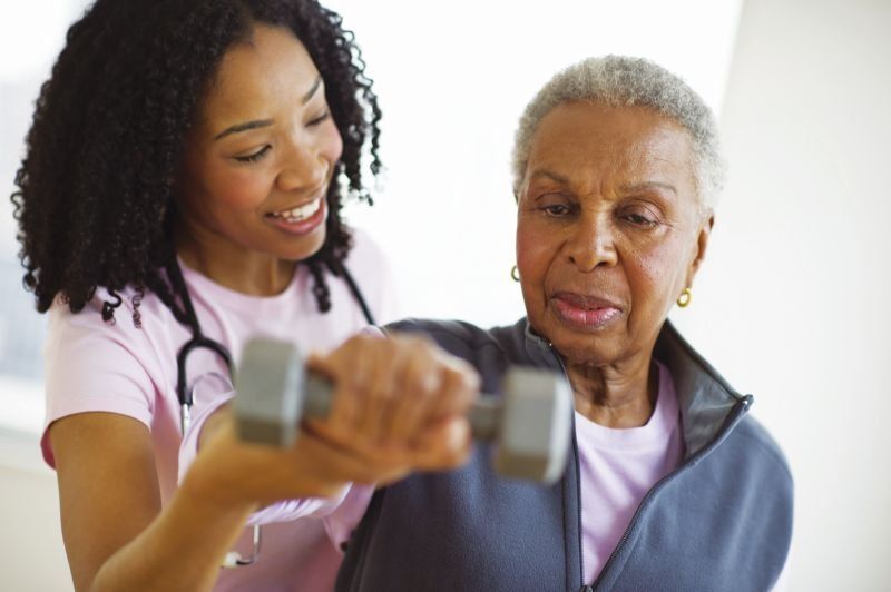 Nurse Helping Elderly Woman Exercise