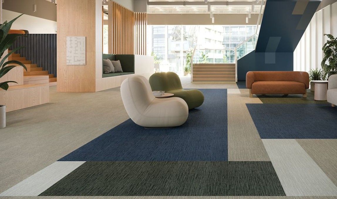 People rolling out a red carpet for an event. Setting is outdoors with white columns.