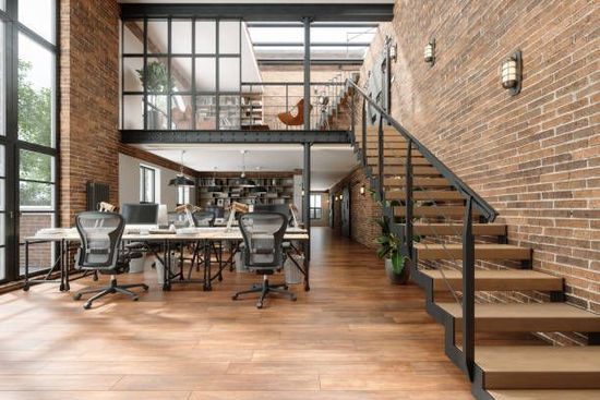 Modern living space with kitchen, living room, light wood floors, and white walls. Includes sofa, TV, plants.