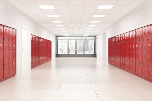 School hallway with red lockers, white walls, and a window at the end.