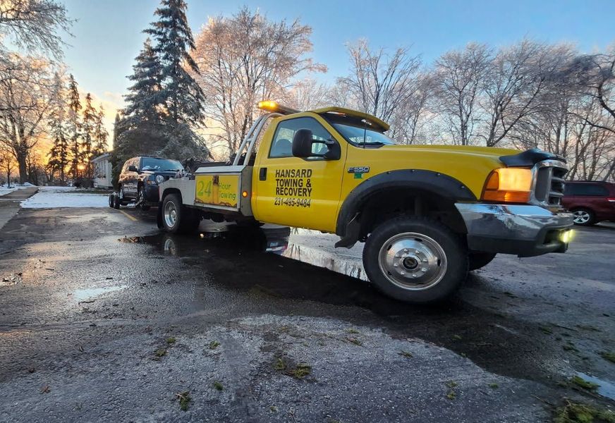 A yellow tow truck is parked on the side of the road