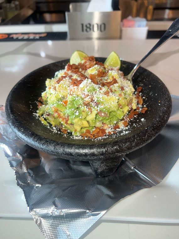 A bowl of guacamole with a spoon in it