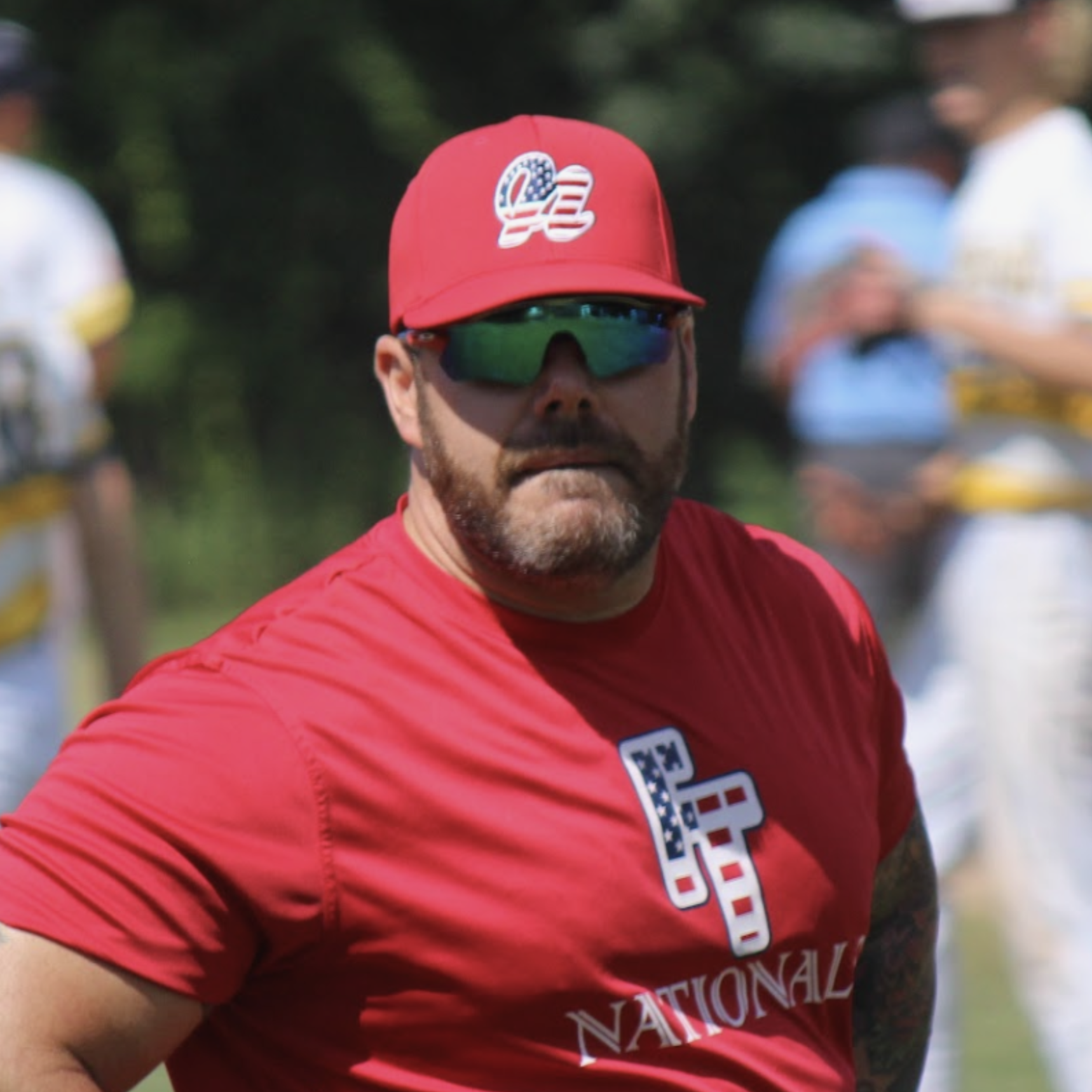 Tally Baseball coach in red cap and sunglasses during training session