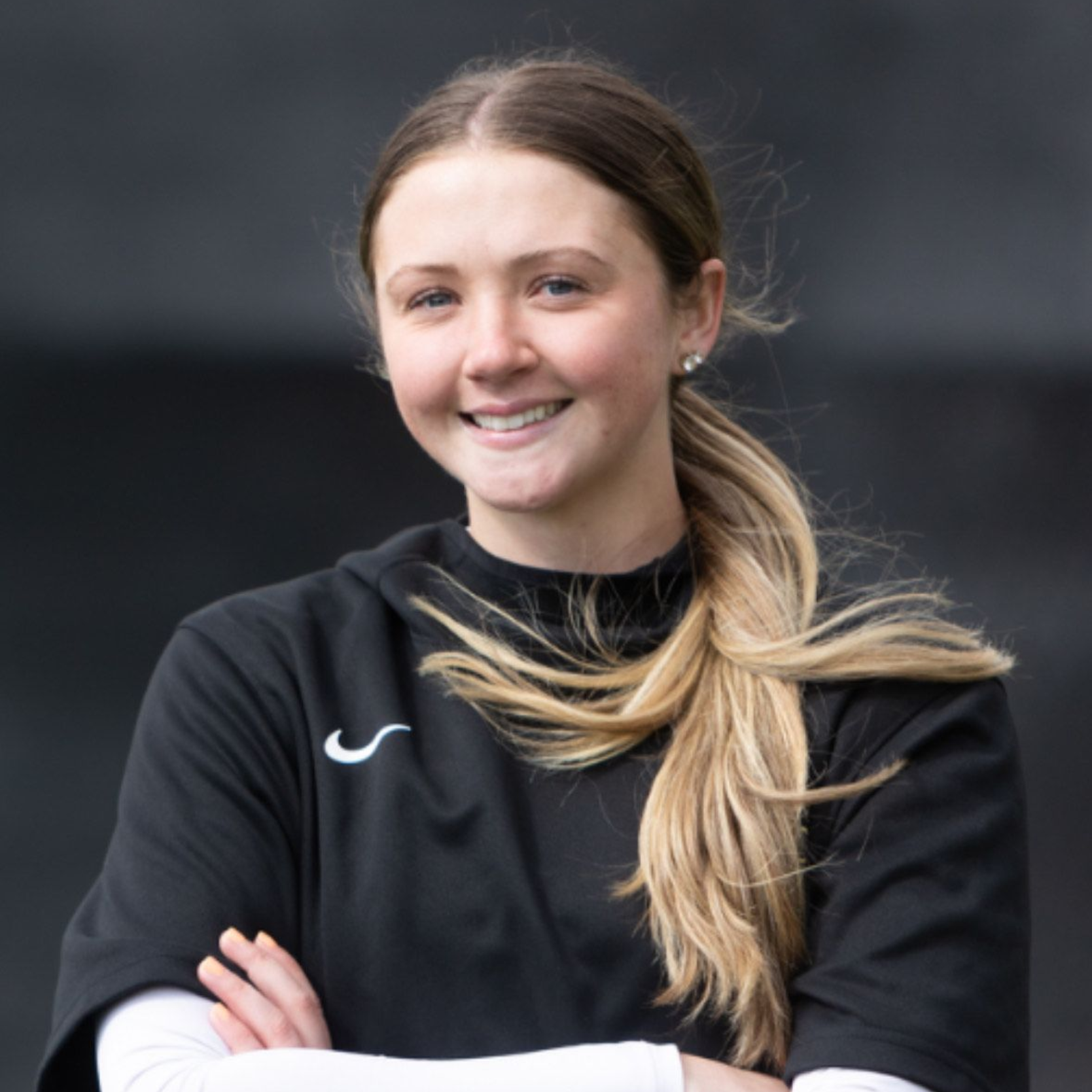 Portrait of Tally Baseball staff member smiling against dark background