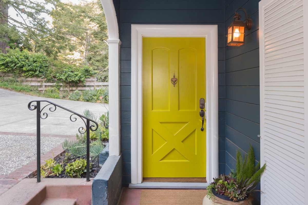 A door being painted a bright color with Aura Grand Entrance paint