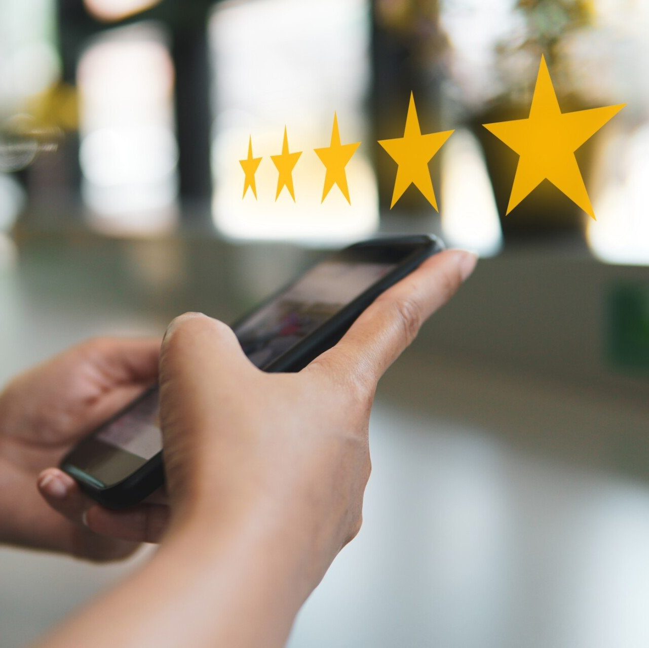 person on smartphone with image of five yellow stars overtop