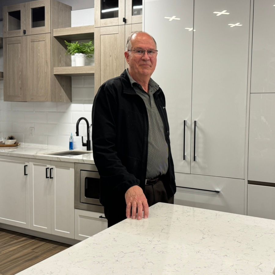 Steve Prentice with Reid Cabinetry stands in front of cabinets in his showroom. 