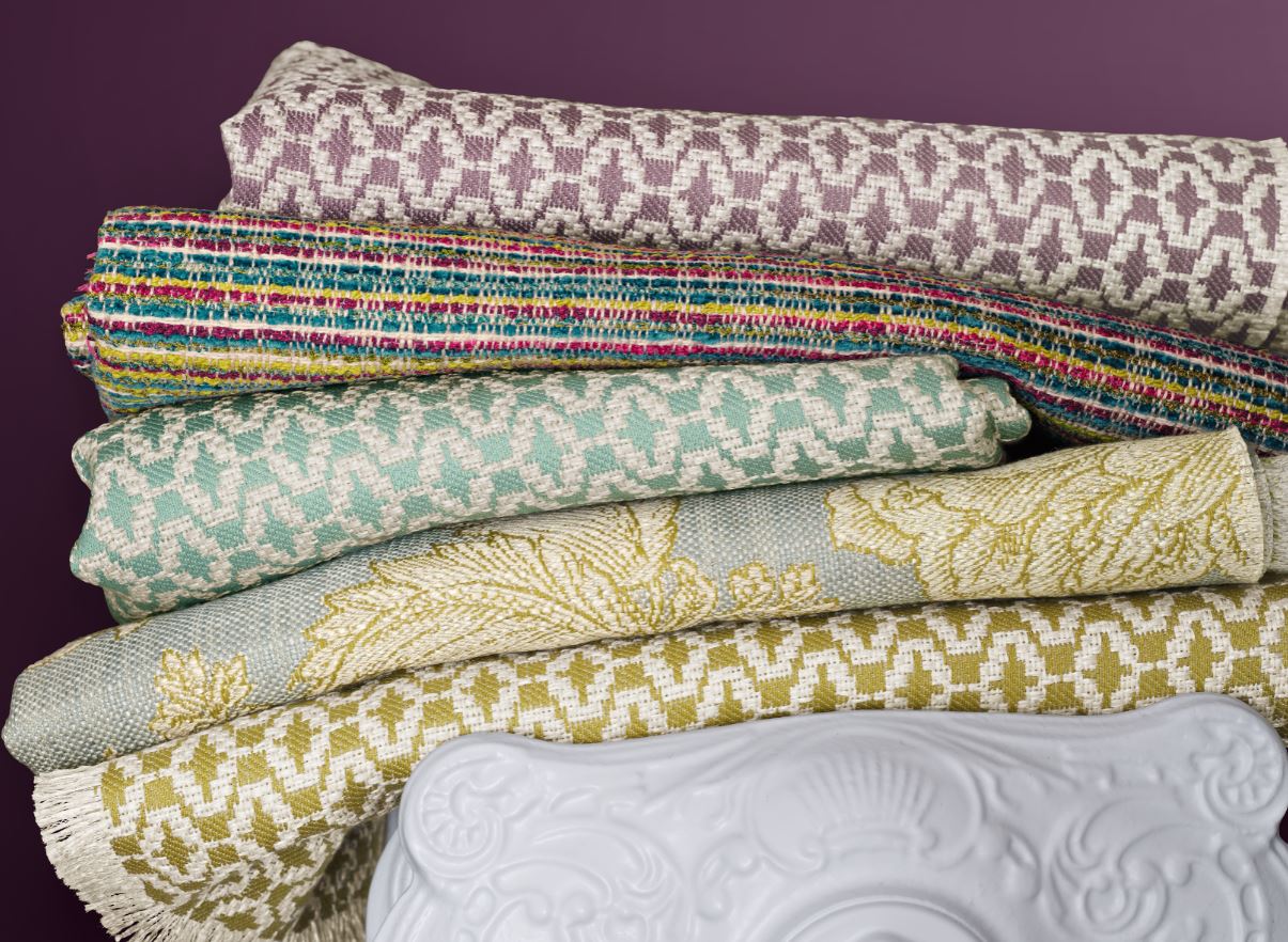 Auf einer weißen Vase liegt ein Stapel Stoffe.