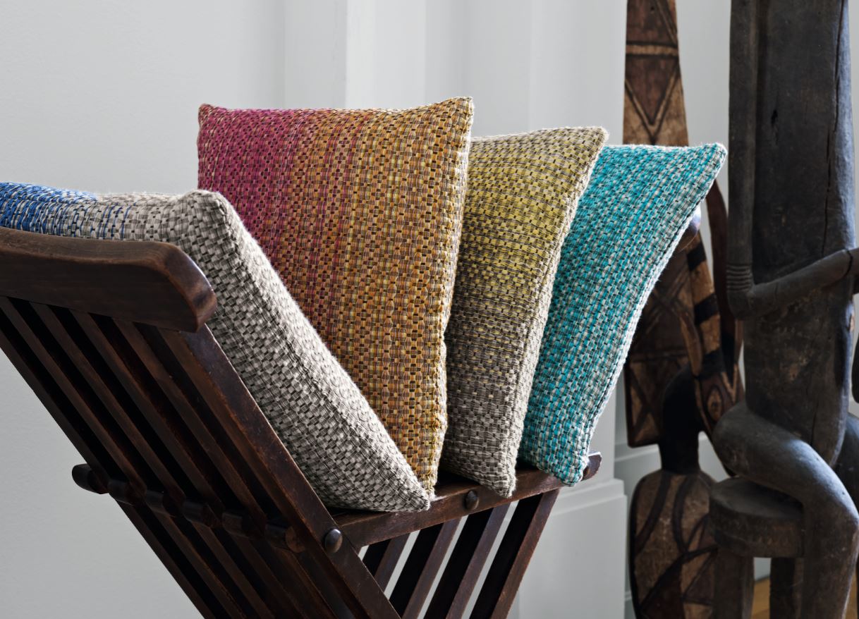 Ein Holzstuhl mit einem Haufen Kissen darauf